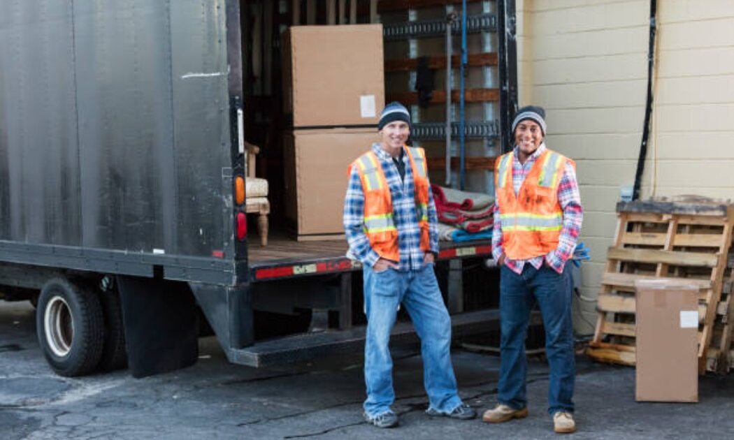 Two movers unloading boxes from a delivery truck