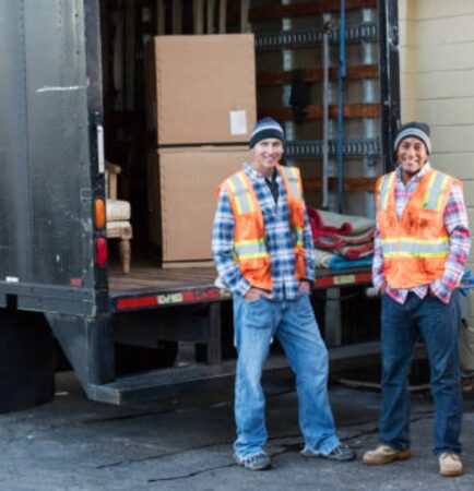 Two movers unloading boxes from a delivery truck
